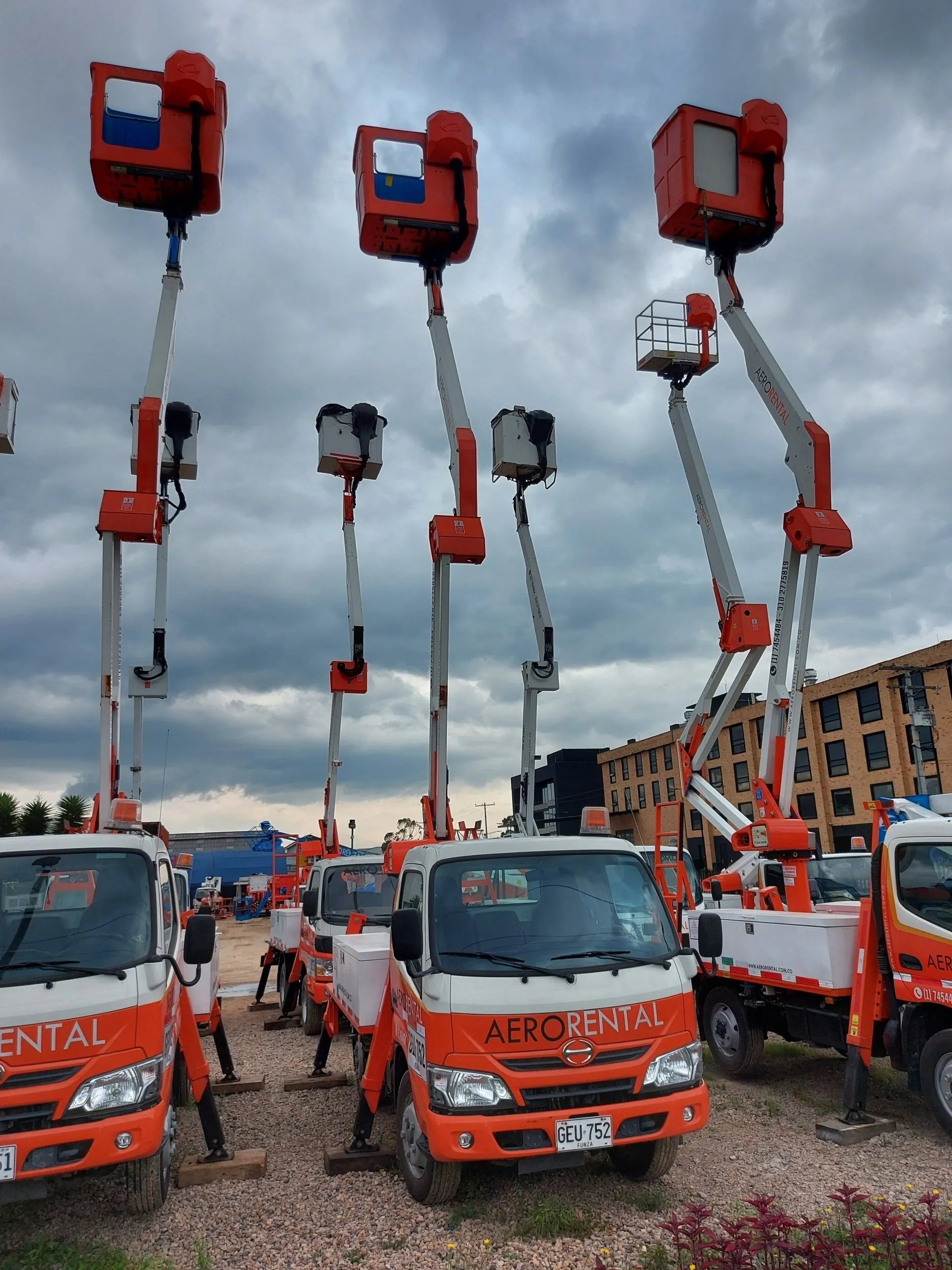 Flota de camiones con canasta y brazos elevadores extendidos de Aerorental