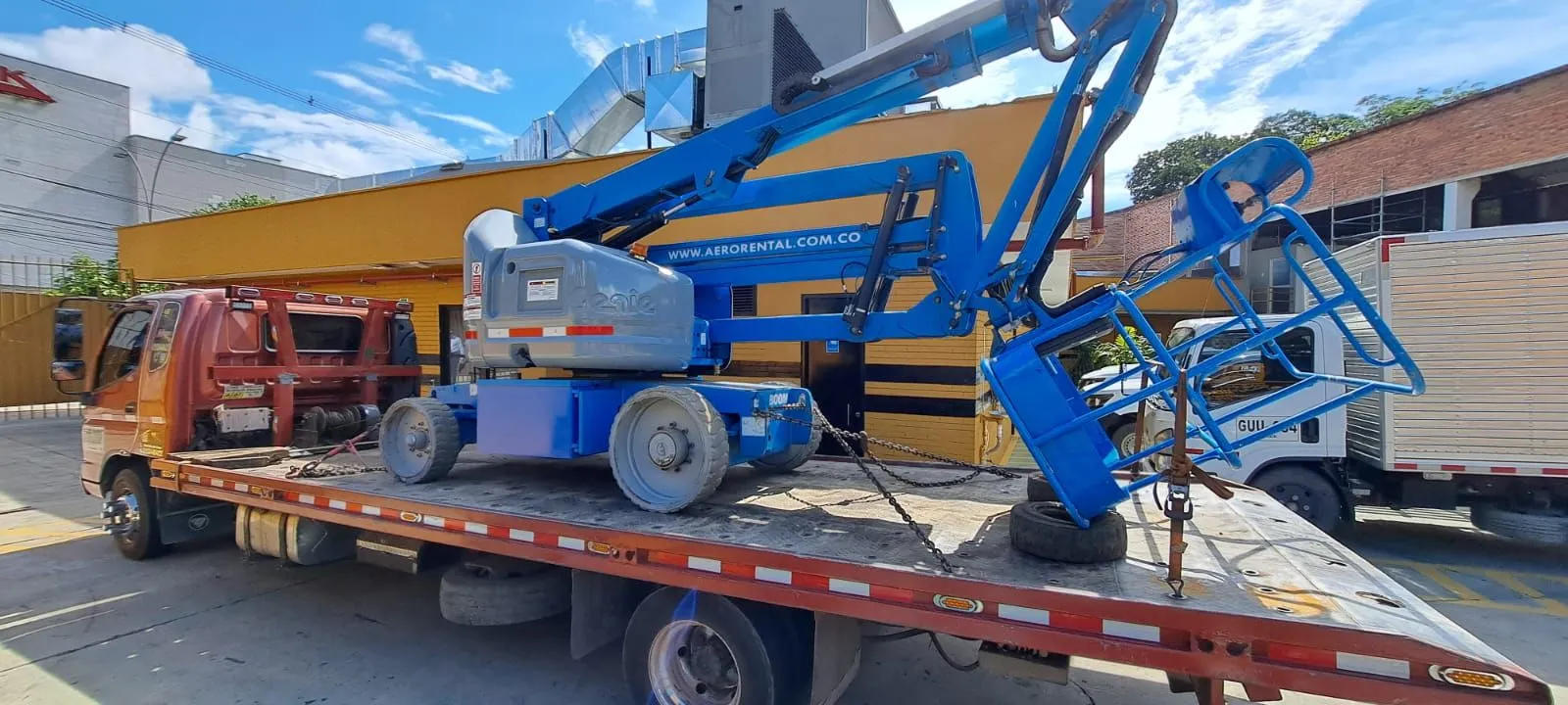 Transporte seguro de plataforma elevadora Genie en camión cama baja en Bogotá por Aerorental